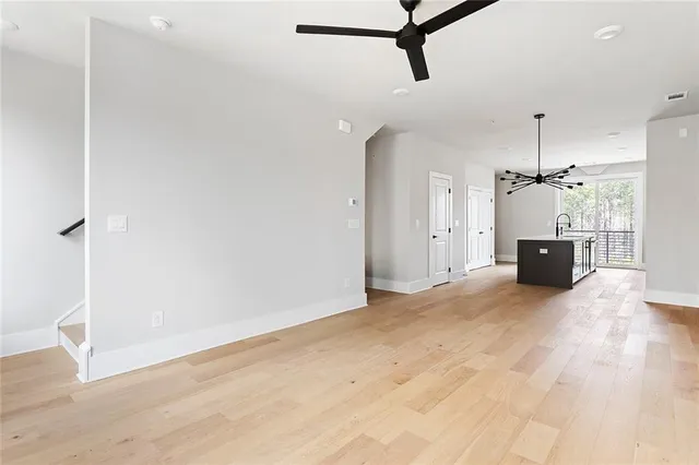 a view of a room with a ceiling fan and a wooden floor