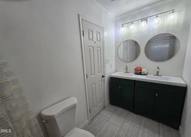 a bathroom with a toilet a sink a mirror and vanity