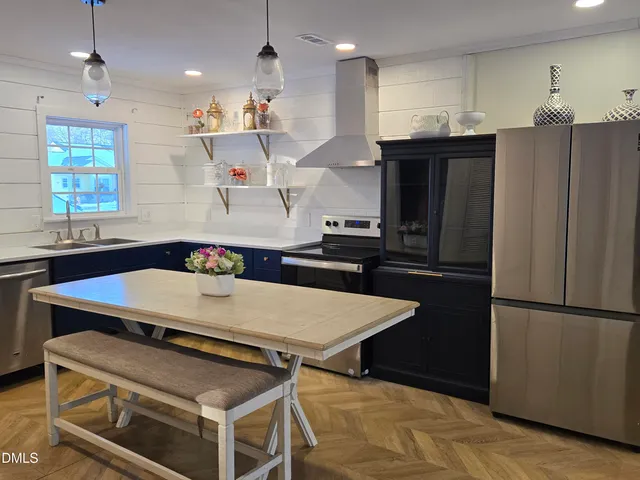 a kitchen with kitchen island a sink appliances and a counter top space