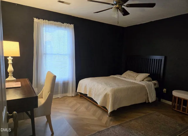 a bed sitting in a bedroom next to a window