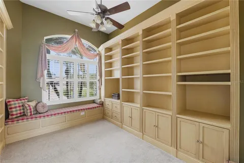 an aerial view of a house with a yard and a large tree