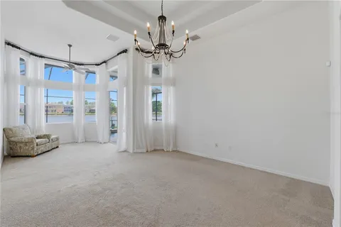 an empty room with a fan & a window
