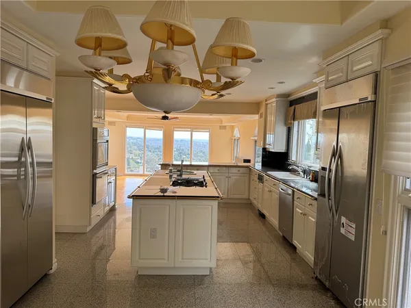 a kitchen with kitchen island granite countertop a sink stove and refrigerator