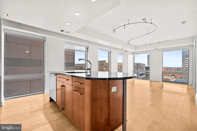 a large kitchen with stainless steel appliances a large counter top a stove and a refrigerator