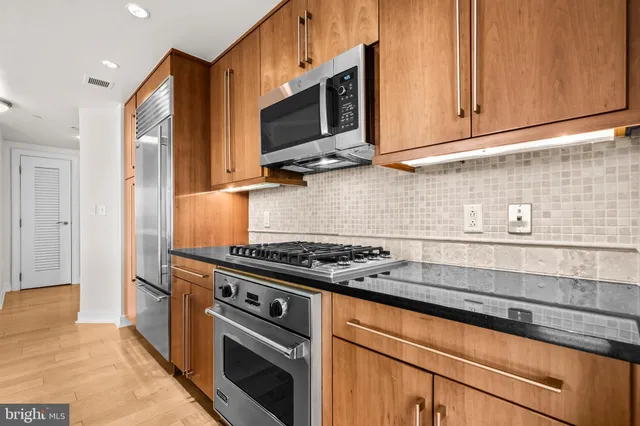 a kitchen with stainless steel appliances granite countertop a sink stove and microwave