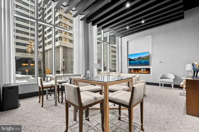 a dining room with furniture and large windows