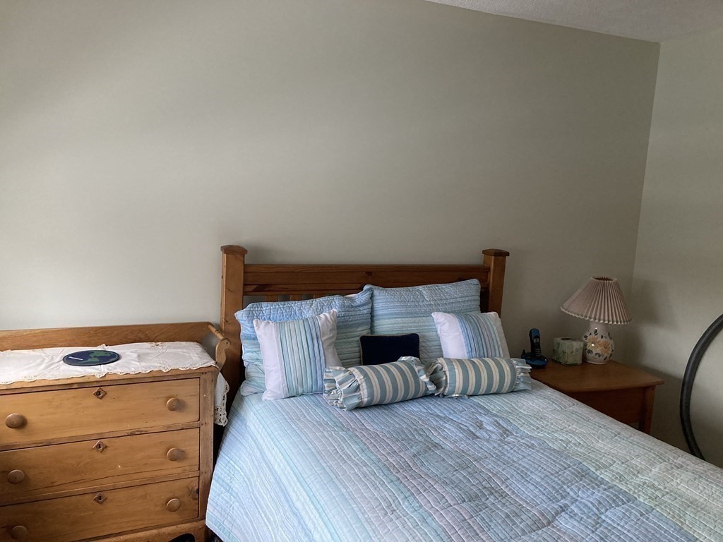 1 Summit Drive, Unit 26 Reading, MA 01867 - Photo 14 of 26 a bedroom with a bed and a mirror