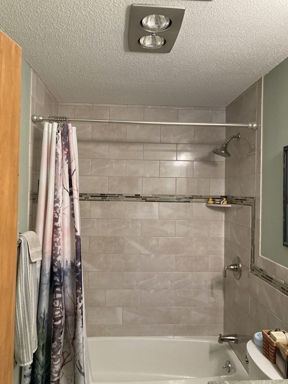 1 Summit Drive, Unit 26 Reading, MA 01867 - Photo 15 of 26 a bathroom with a shower and a bath tub