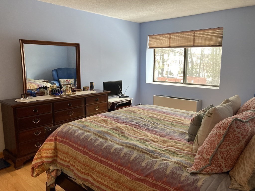 1 Summit Drive, Unit 26 Reading, MA 01867 - Photo 18 of 26 a bedroom with a bed and a dresser in it
