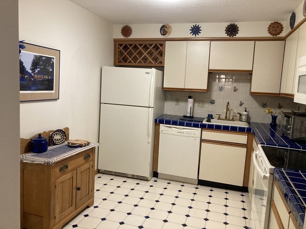 1 Summit Drive, Unit 26 Reading, MA 01867 - Photo 7 of 26 a kitchen with a refrigerator and a stove top oven