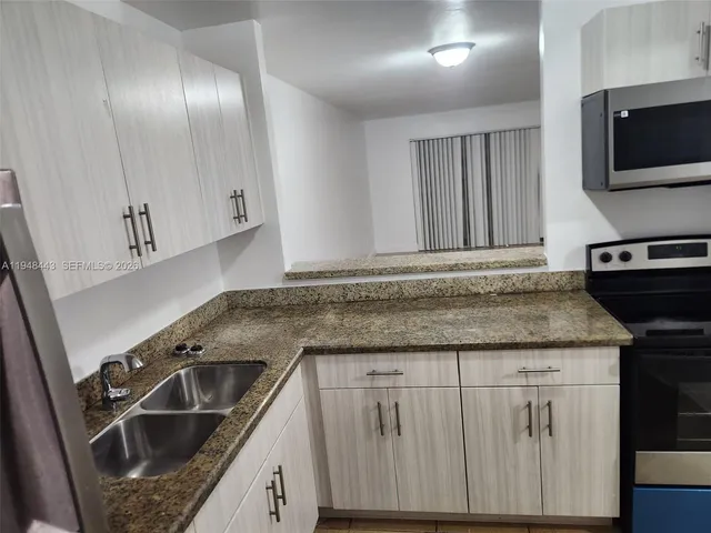 a kitchen with granite countertop a sink and a stove