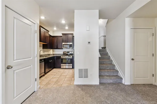 a view of a kitchen with refrigerator and wooden floor