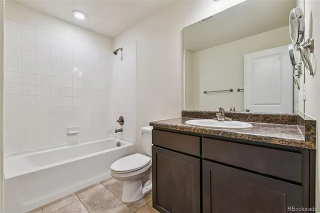 a bathroom with a granite countertop sink a toilet and a bathtub