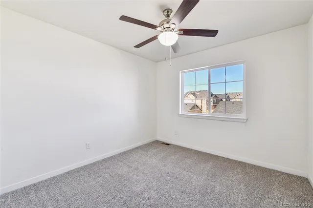 a view of empty room with ceiling fan