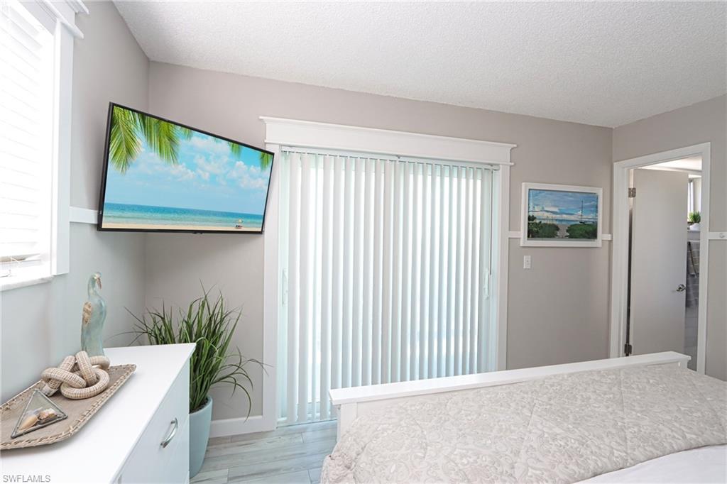 766 Central Avenue, Unit 112 Naples, FL 34102 - Photo 11 of 18 a bedroom with a bed and wooden floor