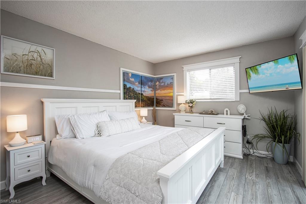 766 Central Avenue, Unit 112 Naples, FL 34102 - Photo 12 of 18 a bedroom with a bed and a large window