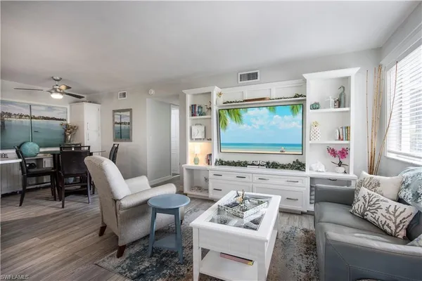 a living room with furniture appliances and a large window