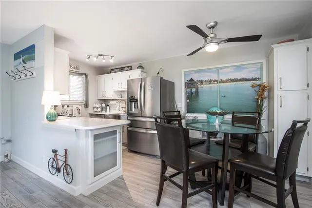 a kitchen with a table chairs refrigerator and cabinets