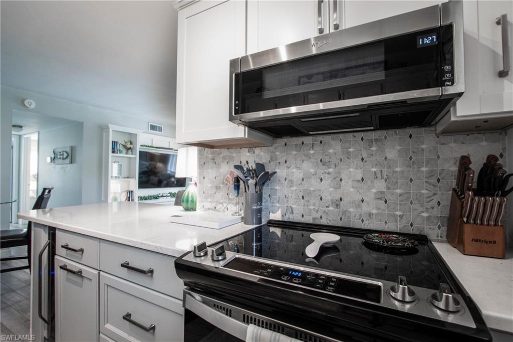 766 Central Avenue, Unit 112 Naples, FL 34102 - Photo 7 of 18 a kitchen with a stove and cabinets
