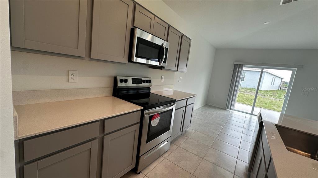 1449 Austin Street Lake Wales, FL 33859 - Photo 4 of 18 a kitchen with a stove and a flat screen tv