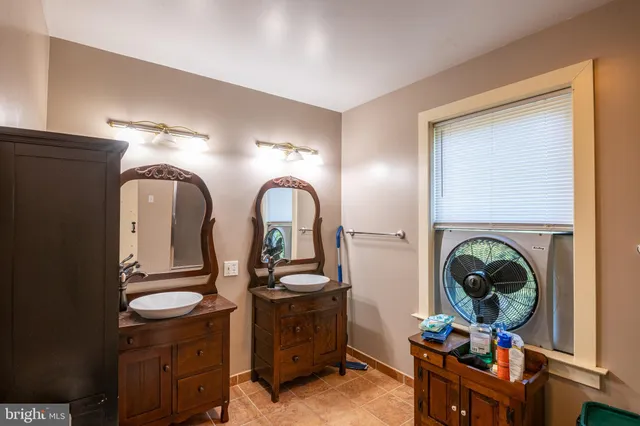 a room with painting on the wall and two windows