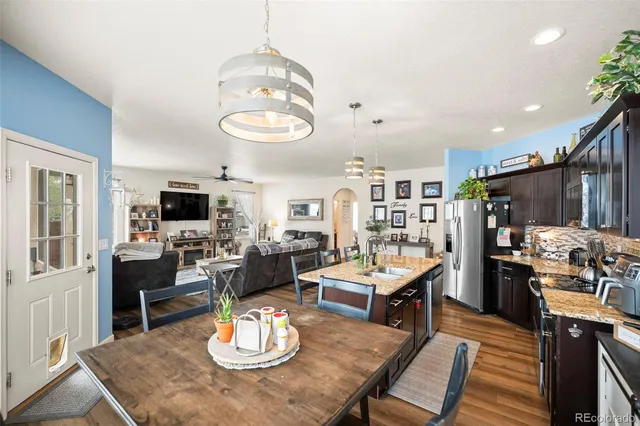 a view of a dining room with furniture a kitchen and chandelier