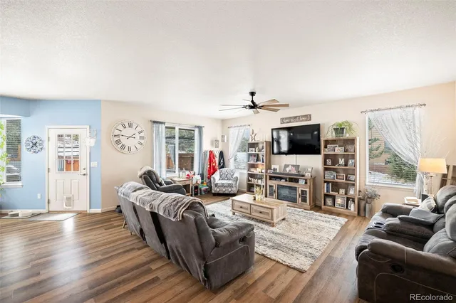a living room with furniture flat screen tv and wooden floor