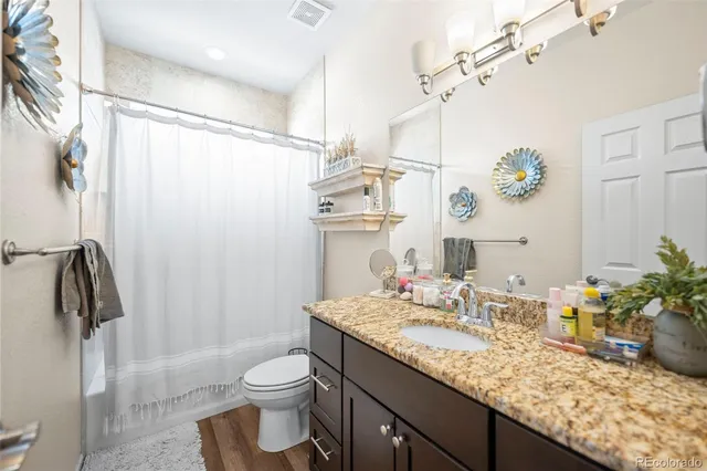 a bathroom with a granite countertop sink toilet and shower