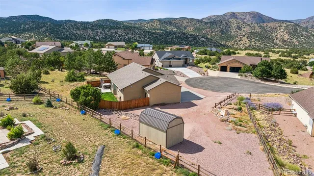 an aerial view of a house with a mountain