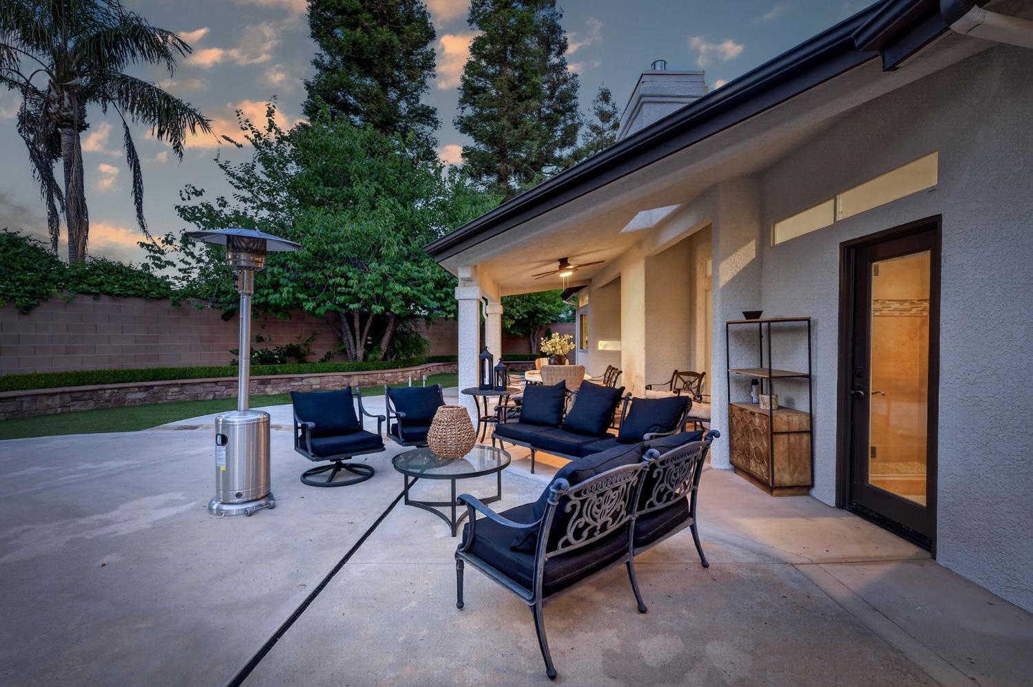 601 Decatur Avenue Clovis, CA 93611 - Photo 44 of 62 a view of a patio with table and chairs potted plants and a palm tree