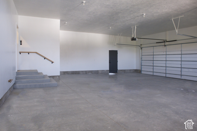 3504 North Sun Dancer Loop Logan, UT 84341 - Photo 25 of 59 Spacious garage featuring a concrete floor, overhead lighting, and an automatic garage door opener
