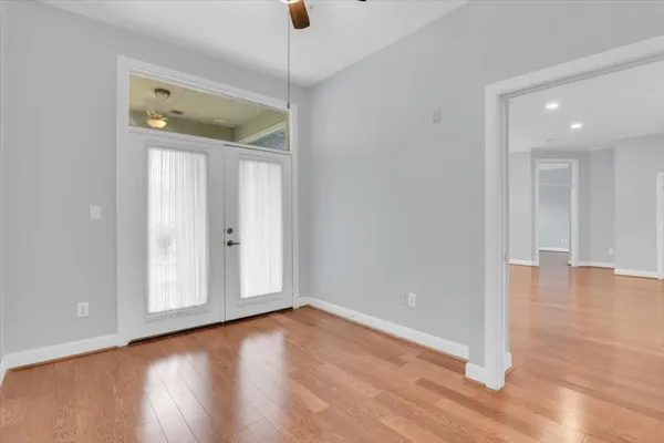 a view of an empty room with wooden floor and a window
