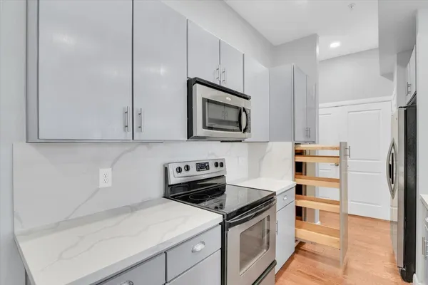 a kitchen with stainless steel appliances a stove top oven a sink a refrigerator a window