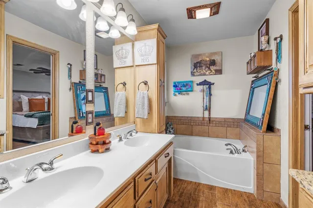 a bathroom with a tub sink and mirror