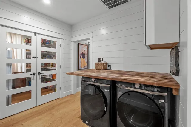 a utility room with stainless steel appliances washer and dryer