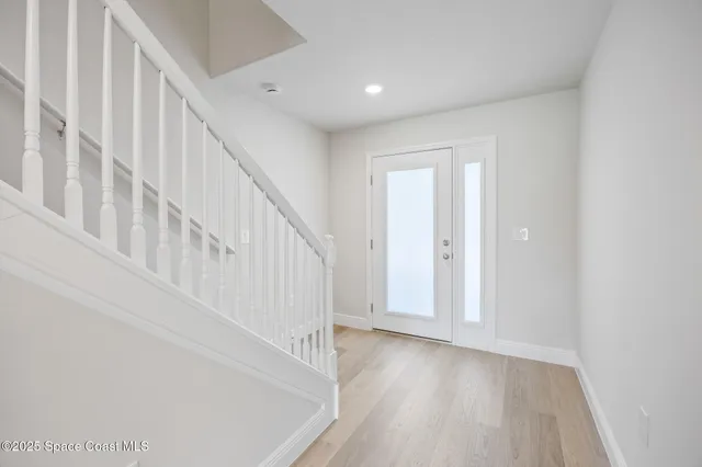 a view of staircase with white walls and white door