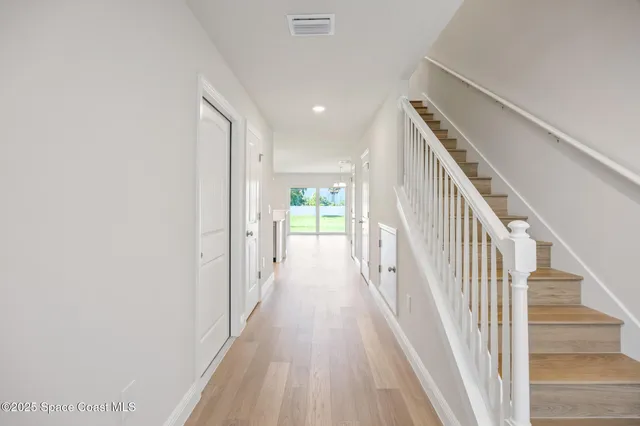 a view of a hallway with wooden floor and entryway