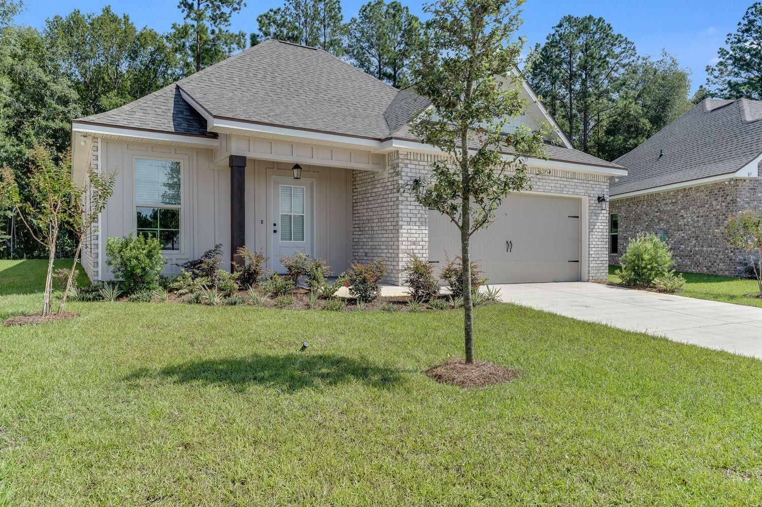 77 Eclipse Loop Freeport, FL 32439 - Photo 2 of 31 a front view of a house with a garden and trees