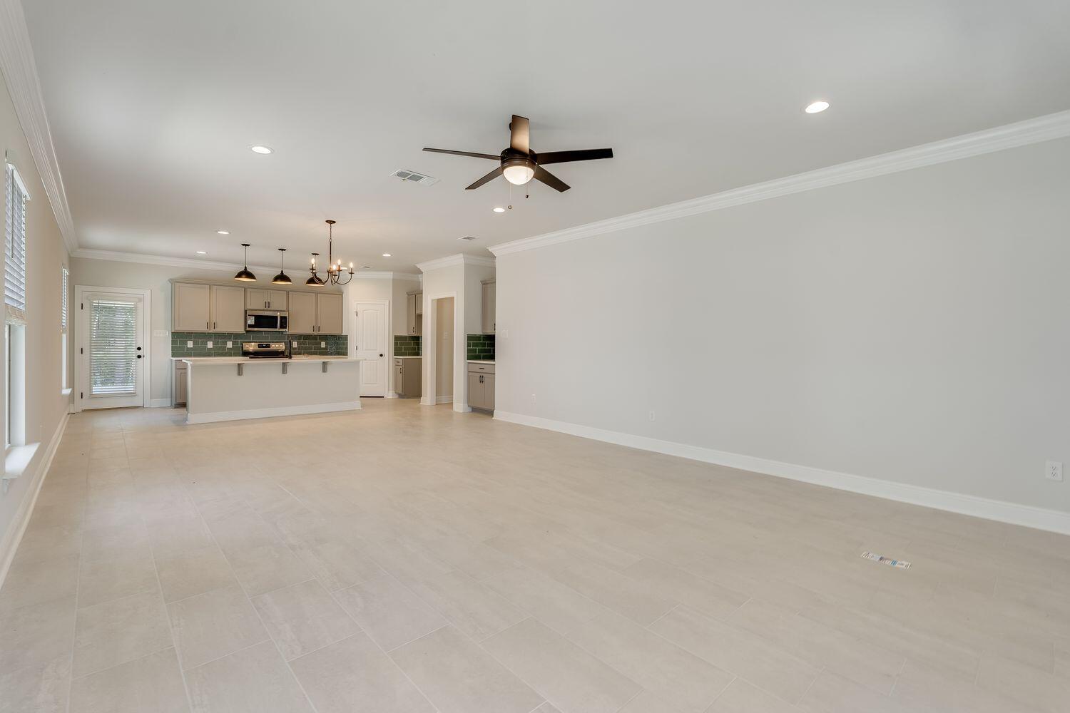 77 Eclipse Loop Freeport, FL 32439 - Photo 7 of 31 an empty room with chandelier and stainless steel appliances