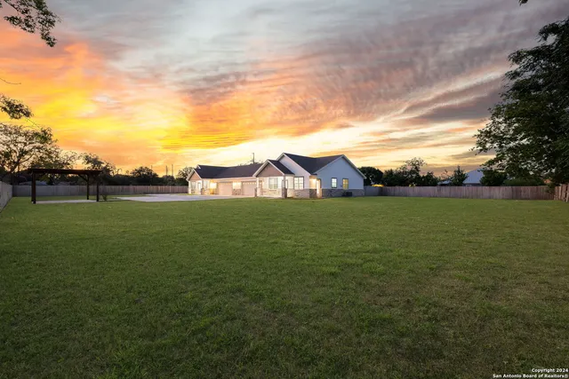 an aerial view of a house with a garden and lake view