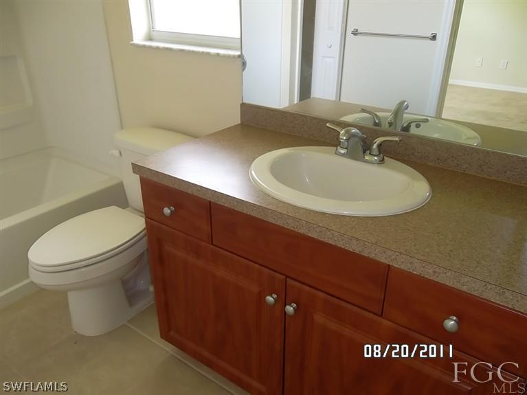 333 Delaware Road Lehigh Acres, FL 33936 - Photo 11 of 14 a bathroom with a toilet sink and mirror