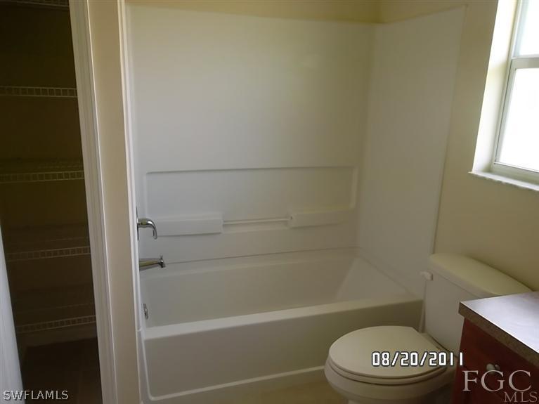 333 Delaware Road Lehigh Acres, FL 33936 - Photo 12 of 14 a bathroom with a toilet and a shower