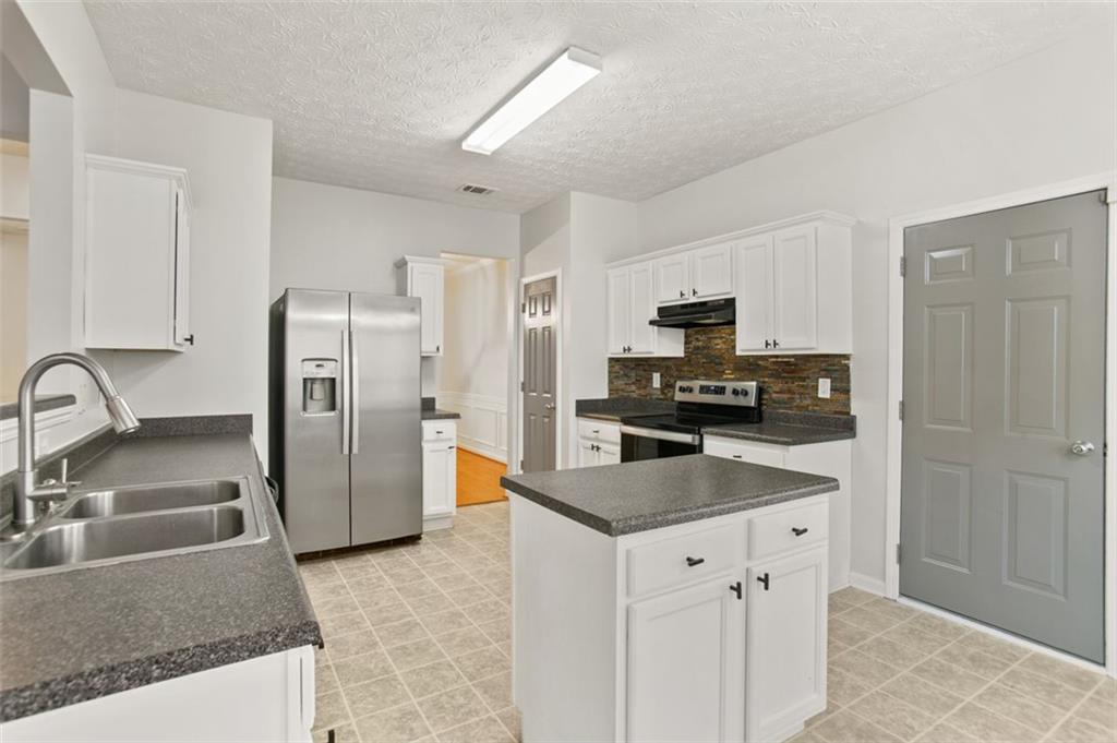 808 Inkberry Road Canton, GA 30114 - Photo 17 of 50 a kitchen with granite countertop a refrigerator and a sink