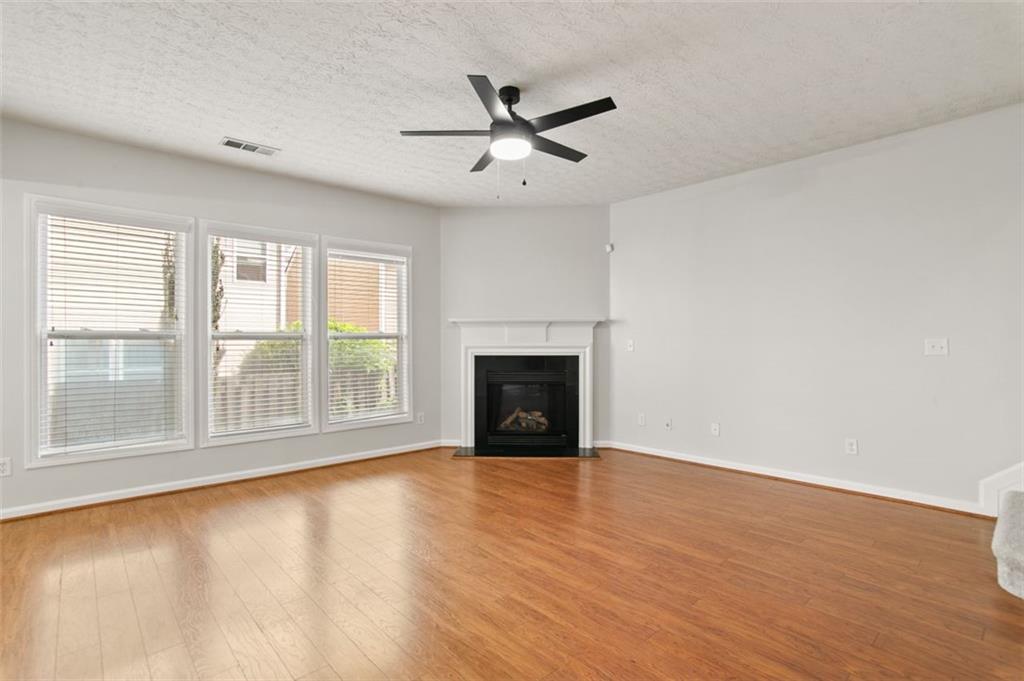 808 Inkberry Road Canton, GA 30114 - Photo 22 of 50 an empty room with wooden floor fan and windows