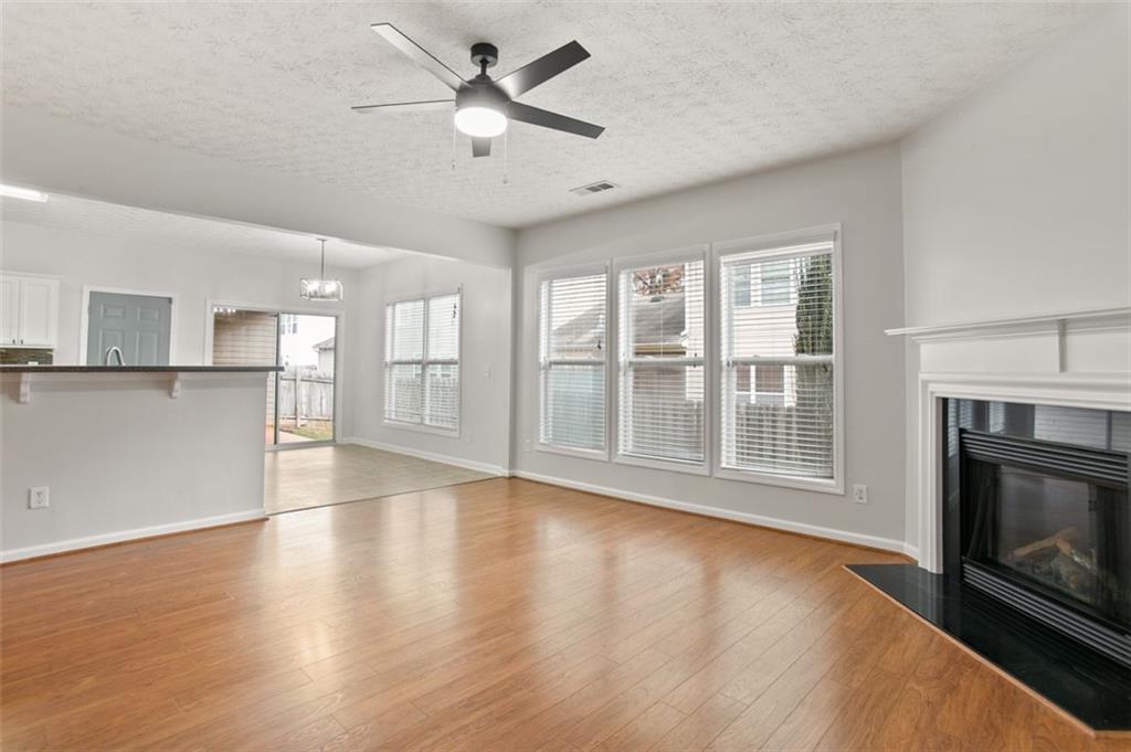 808 Inkberry Road Canton, GA 30114 - Photo 23 of 50 a view of an empty room with wooden floor and a kitchen