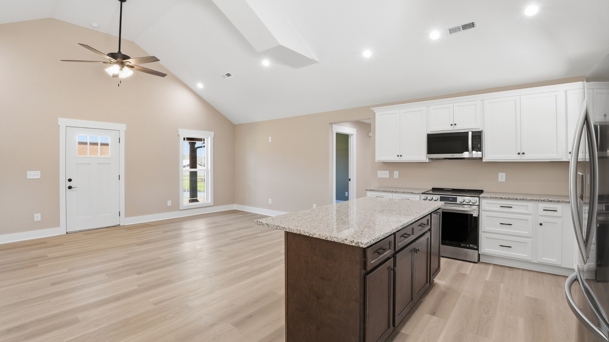 104 Division Street Normandy, TN 37360 - Photo 14 of 48 a kitchen with stainless steel appliances granite countertop a stove top oven a sink dishwasher and a refrigerator with wooden floor