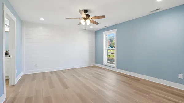 a bedroom with a bed and wooden floor