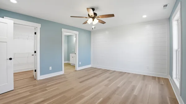 wooden floor in an empty room with a ceiling fan