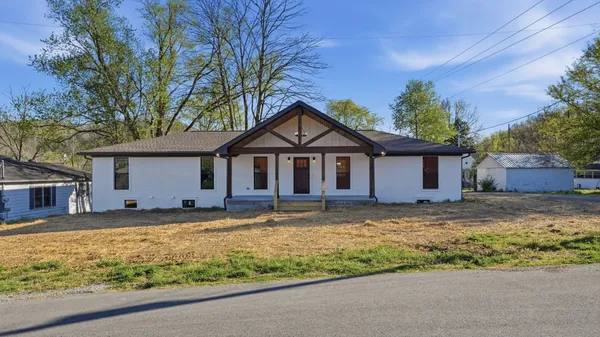 a front view of house with yard and trees around