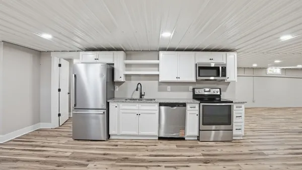 a kitchen with stainless steel appliances granite countertop a stove a sink and a refrigerator